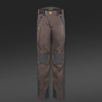 Die 5WL Wasserdichte Regenhose von Hillman ist eine ultraleichte braune Hose mit verstärkten Kniebesätzen, blauen Akzenten, Gürtelschlaufen, Reißverschlusstaschen und Jagdhosen-Branding auf dem Oberschenkel vor dunklem Hintergrund.