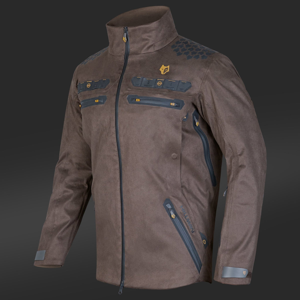 Die Hillman 6OL Winter-Jagdjacke in Camouflage ist eine braune Jacke mit hohem Kragen, Camouflage-Akzenten und gelben Highlights auf dunkelgrauem Grund. Sie verfügt über mehrere schwarze Reißverschlüsse, Brust- und Seitentaschen mit Reißverschluss, ein sechseckiges Schultermuster und ein kleines Logo auf der linken Brust. Ideal für das Winterjagderlebnis.