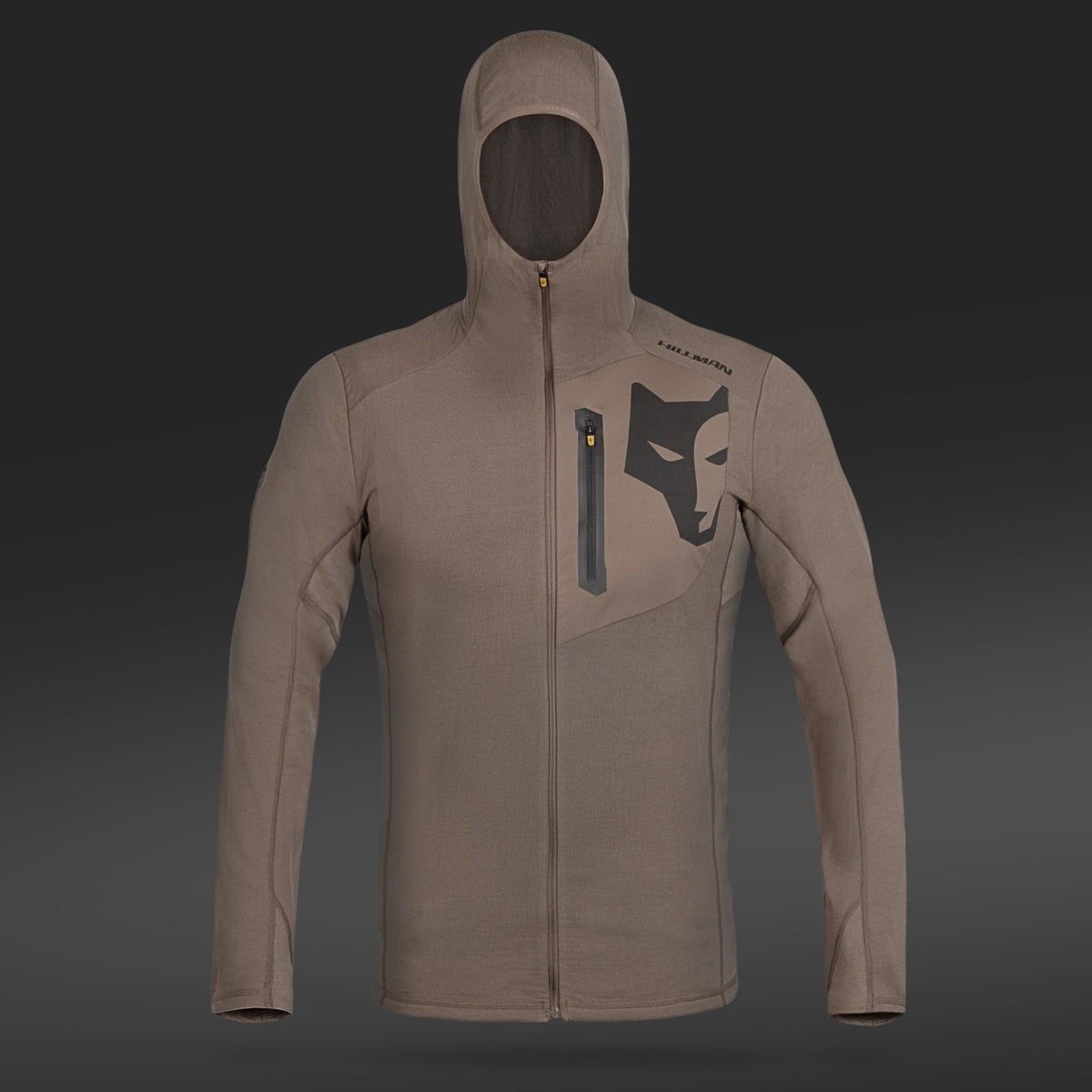 Der Hillman 3ML Jagd Hoodie ist ein Kapuzenpullover aus hellbrauner Merinowolle mit einem schwarzen Wolfslogo auf der Brust, einem Reißverschluss vorne und einer vertikalen Brusttasche mit Reißverschluss vor einem dunklen Hintergrund mit Farbverlauf.