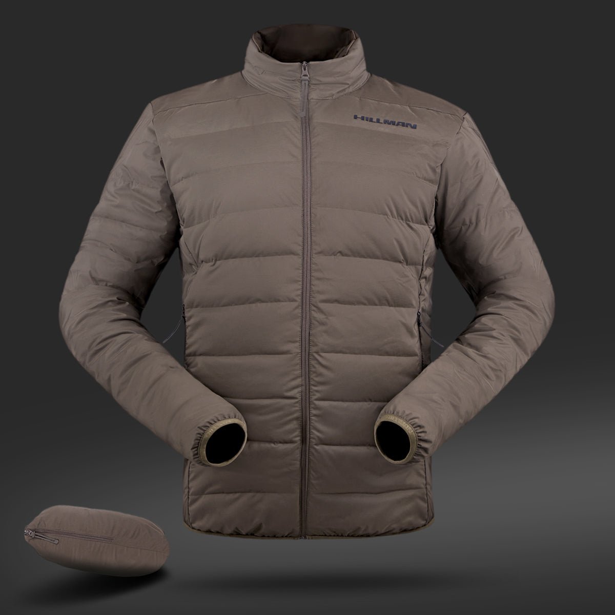 Die 4IL Winter Daunenjacke von Hillman ist eine leichte, braune Jacke mit hohem Kragen und zwei Reißverschlusstaschen. Der Markenname ist auf dunklem Hintergrund auf der Brust sichtbar. Sie verfügt über eine hervorragende Kälteisolierung und wird mit einem kleinen, passenden Beutel geliefert.