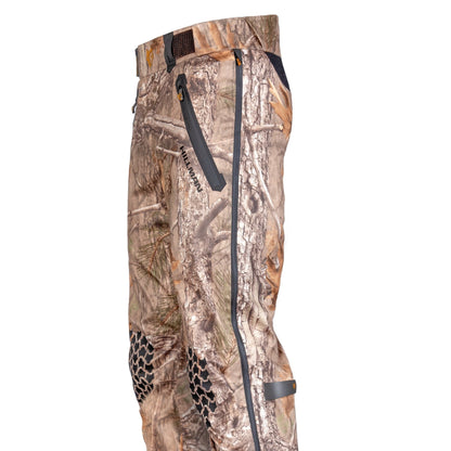 Die 5WL Wasserdichte Regenhose von Hillman (in der Seitenansicht) besteht aus Stoff mit Camouflage-Muster in Braun- und Grüntönen, schwarzen Reißverschlüssen und Kniepolstern für mehr Strapazierfähigkeit.