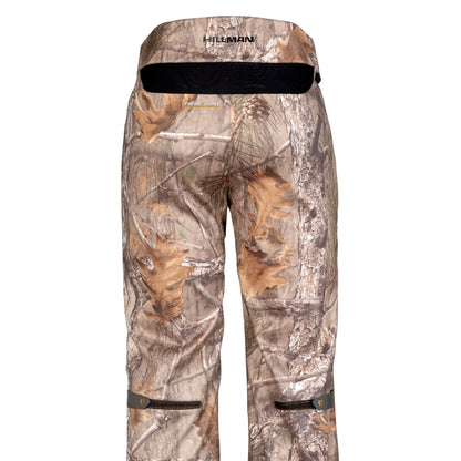Die 5WL Wasserdichte Regenhose von Hillman ist eine Jagdhose im Tarnmuster mit einem Waldmuster aus Blättern und Zweigen, einem schwarz akzentuierten Bund mit dem Markenlogo und verstellbaren Riemen im Unterschenkelbereich, ideal für das Erscheinungsbild im Waldgelände.