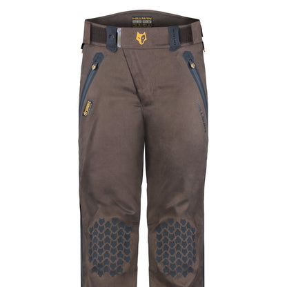 Die Hillman 5WL Wasserdichte Regenhose besticht durch ihr braunes Design mit schwarzen, verstärkten Kniebesatz, gelben Reißverschlüssen an den Vordertaschen, Gürtelschlaufen und einem Logo-Patch am Bund. Sie eignet sich für raue Aktivitäten und kann bei unvorhersehbarem Wetter auch als ultraleichte Regenhose getragen werden.