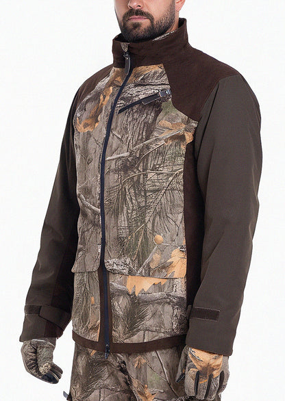 Eine Person, die die Hillman Tarnjacke Jagd | Jagdjacke Camouflage - Fusion 3DX mit Tarnmuster und einfarbig braunen Ärmeln trägt, steht vor einem unifarbenen Hintergrund. Nur die untere Hälfte des Gesichts ist sichtbar, was diese elegante Jagdjacke hervorhebt.