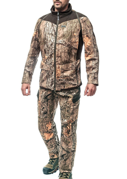 Eine Person, die Hillmans Camouflage-Hose – Tarnhose, Sommer-Jagdhose XPR aus Cottonsuede® in natürlichen Erdtönen und Mustern trägt, rundet den Look mit grünen Stiefeln ab, die sowohl Stil als auch Funktionalität für Outdoor-Abenteuer bieten.