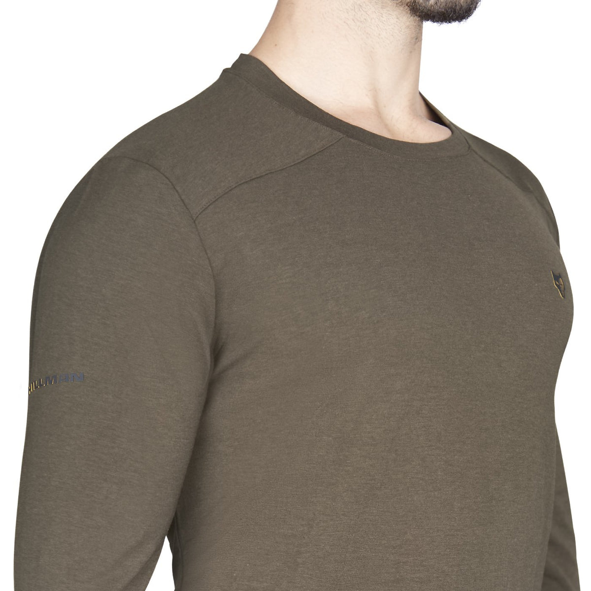 Eine Person trägt das taillierte Hillman 1UL Langarmshirt Bambus, ein olivgrünes Langarmshirt aus Bambusfasern mit kleinem Logo auf der Brust und dezentem Ärmeltext, das für seine feuchtigkeitsregulierenden Eigenschaften bekannt ist. Kopf und Unterkörper sind nicht sichtbar.