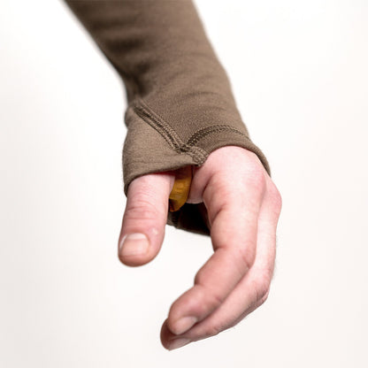 Ein hellbrauner Ärmel mit Daumenloch vom Hillman 3ML Jagd Hoodie – Merinowolle Jagdpullover ist teilweise sichtbar und präsentiert den strukturierten Merinowollstoff vor einem glatten Hintergrund.
