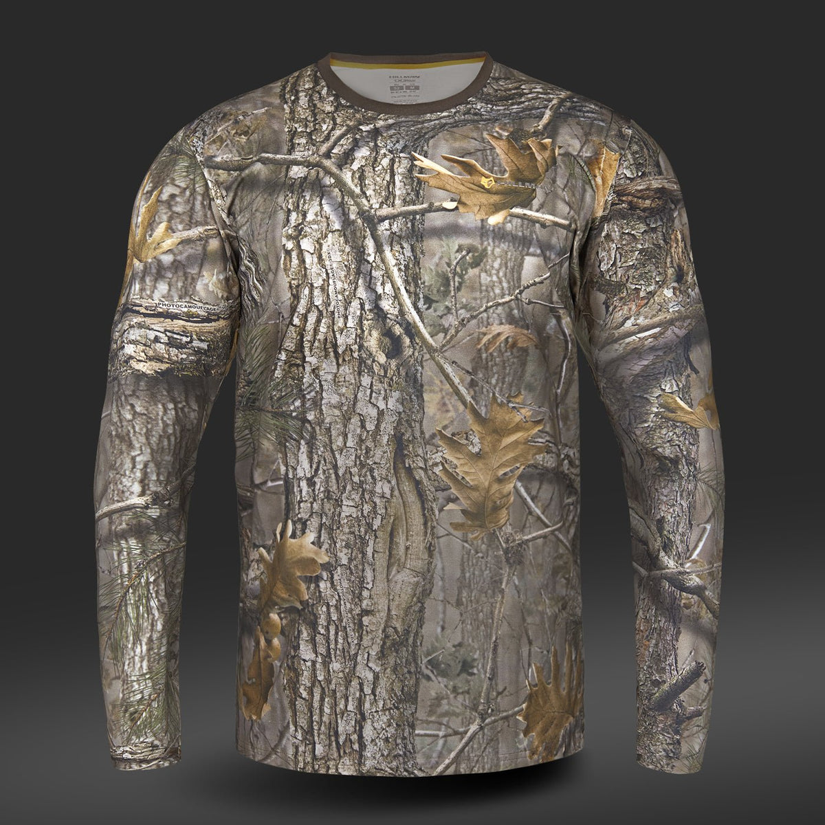 Das Baumwoll-T-Shirt Langarm von Hillman verfügt über ein Baumrinden- und Blatt-Tarnmuster aus hautfreundlicher ägyptischer Baumwolle vor einem dunklen Hintergrund.